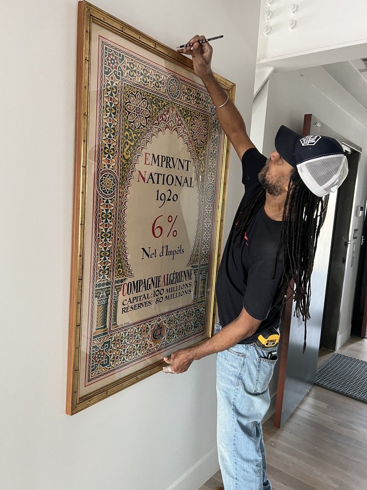 The contractor fixing the painting alignment.