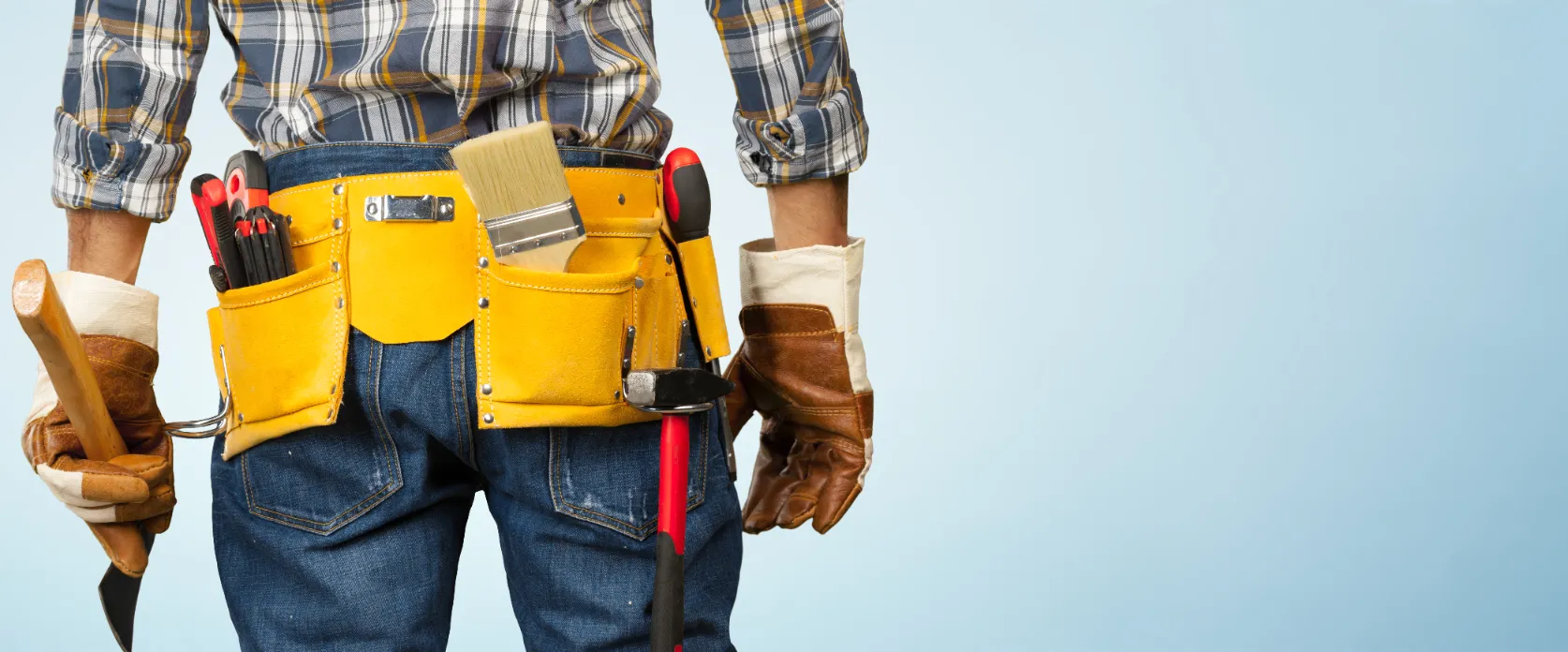 A construction worker ready for a task with tools on his belt